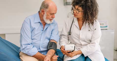 Médico tomando la presión a un paciente